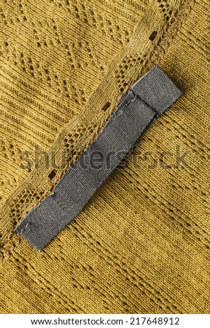 Yellow knitted cloth with black label closeup