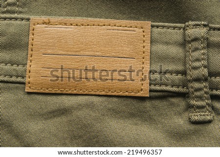 Blank leather label on khaki cloth as a background