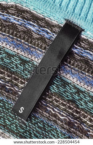 Black size label on knitted cloth as a background