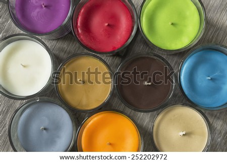 Group of multicolor aromatic candles on wooden background