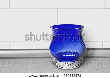Blue glass empty vase on a table closeup