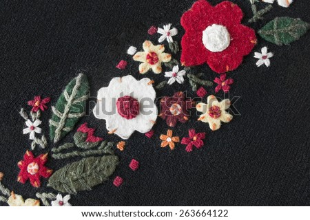 Felt flowers on black knitted cloth as a background