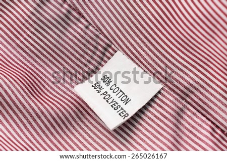 Fabric composition label on red striped cloth as a background