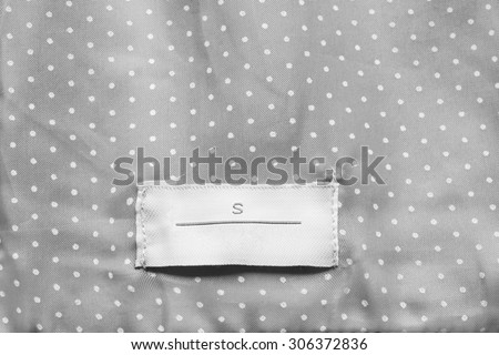 White clothes label on gray silk as a background