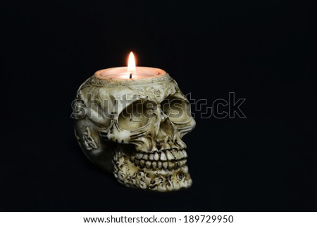 creepy skull candle on black background - half turn