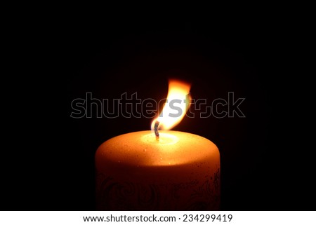 White christmas candle burning on a black background