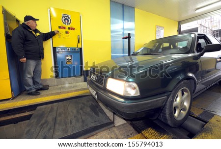 BELGRADE, SERBIA - CIRCA NOVEMBER 2011: Worker inspects vehicle at technical inspection of vehicles center, circa November 2011 in Belgrade