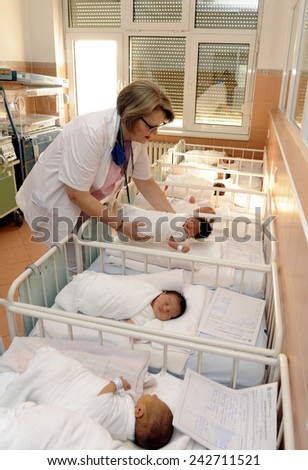 BELGRADE, SERBIA - CIRCA DECEMBER 2014: Nurse takes care of unidentified new born babies in maternity hospital, circa December 2014 in Belgrade