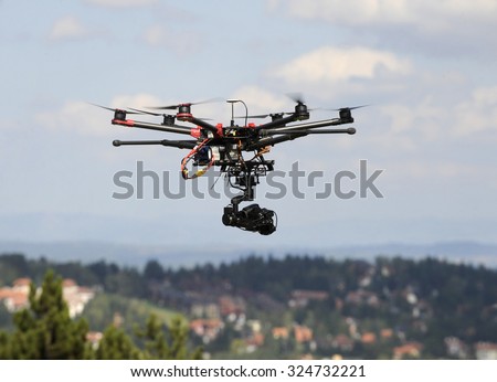A drone with a camera flying high above a residential area