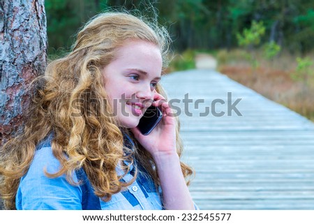 Blonde girl phoning mobile in nature