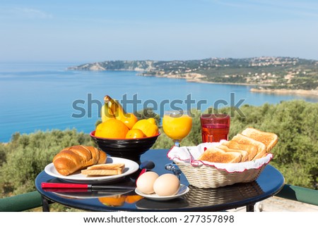 Table with food and drinks in front of sea on island