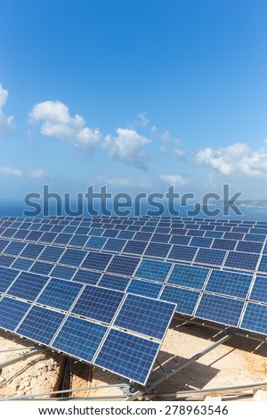 Field of solar collectors near sea with blue sky