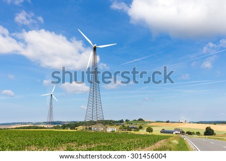 Two windmills in countryside with blue sky and white clouds in Germany