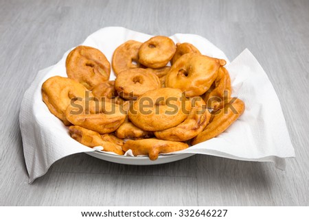 Many apple fritters with white napkins on scale