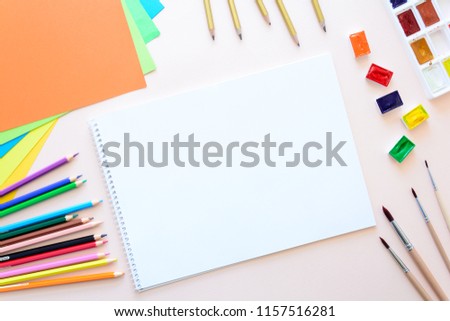 School stationery on pink paper. Colored pencils, pens, pains, paper, brushes for school and student education. Back to school. Copy space. Top view. Flat lay