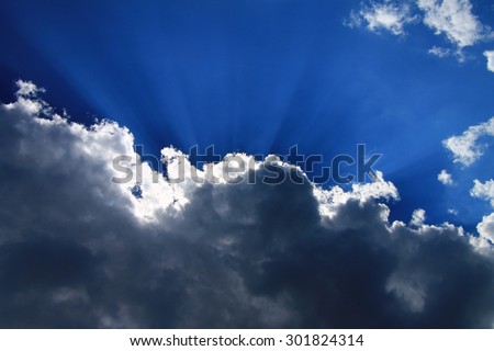 Beautiful sky with blue sun rays and dynamic clouds after the rain
