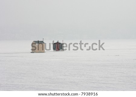 Pair of Ice Houses on Frozen Lake in the Morning Fog