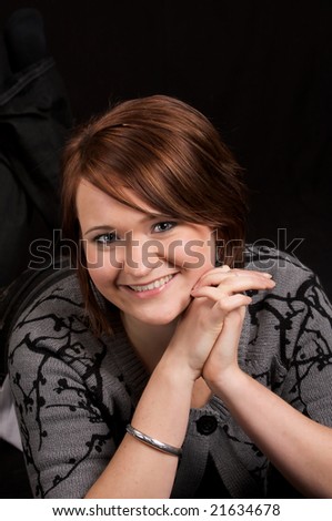 Beautiful Russian Woman lying on stomach with smile in modest attire