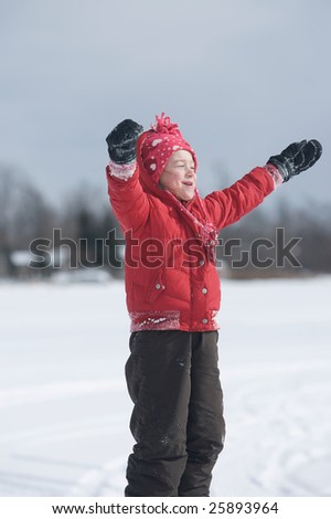Young girl playing outside in the snow