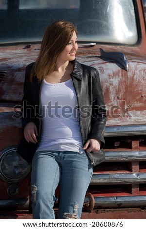 Young pretty red headed woman by an old truck
