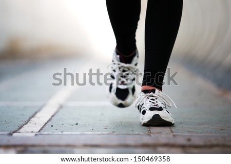 Runner Feet Walking On Road Closeup On Shoe. Woman Fitness Jog Workout Wellness Concept.