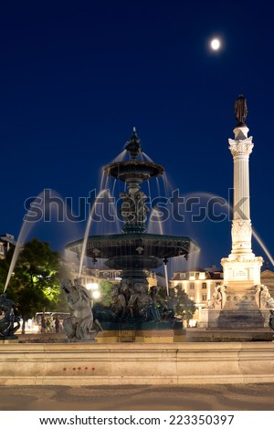 night view of Baroque fountain on rossio square the liveliest placa in Lisbon with Pedro King Statue on background