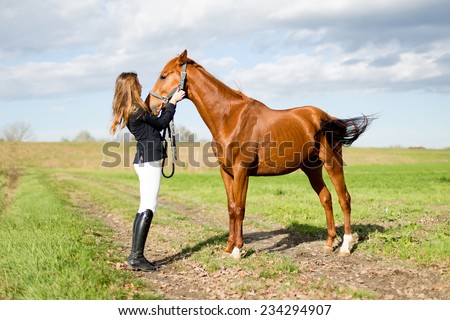 Beautiful young girl talks with her horse dressing uniform competition: outdoors portrait on sunny day