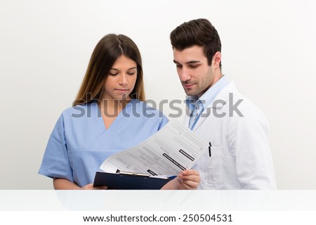young doctor speaking with female nurse and check medical information : they discussing together on medical exam at hospital