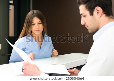 young doctor speaking with female nurse and check medical information : they discussing together on medical exam at hospital