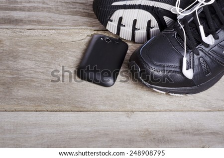 Pair of sport shoes  and mobile phone fitness accessories