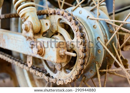 Old dirty motorcycle chain on wheel with rusty metal parts.