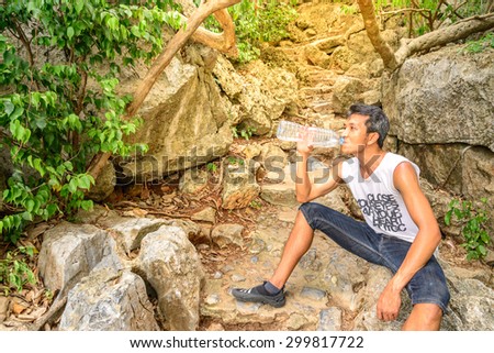 Man hiker drinking water in roasting day.