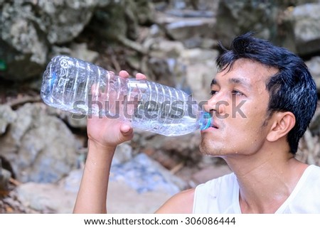 Man hiker drinking water in roasting day.