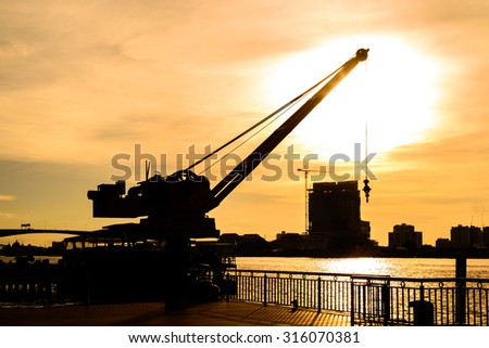 Silhouette crane working at port with sunset in Bangkok, Thailand.