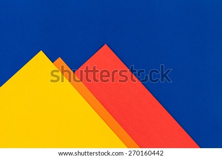 Color papers geometry flat composition background with yellow orange red and blue tones