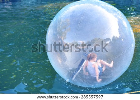 Children Playing inside the water ball in the swimming pool