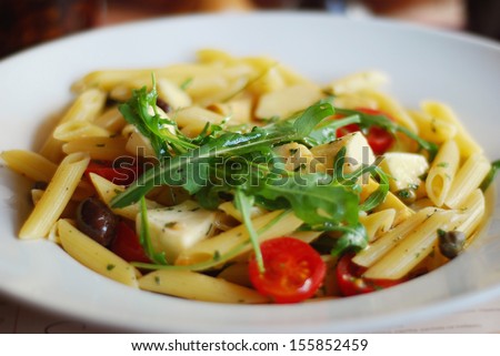 Fusili pasta salad, with rocket pesto, juicy tomatoes, olives and onion.Fresh pasta with tomato, rocket, cheese and olive/Pasta salad/Pasta Salad with Tomatoes and Olives