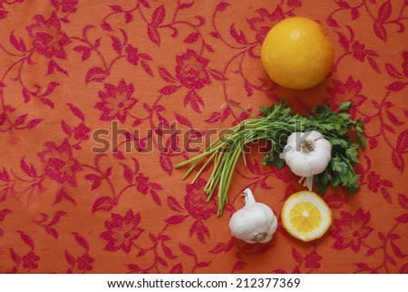 High above view on fresh organic fruit and vegetable/Organic food on table/Fresh organic raw orange fruit, parsley and onion on flower tablecloth.
