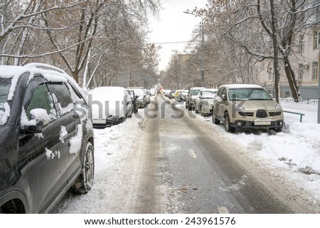 an image of snow covered cars in parking lot