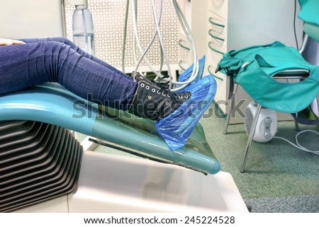 patient\'s legs In a shoes covers in a dental chair