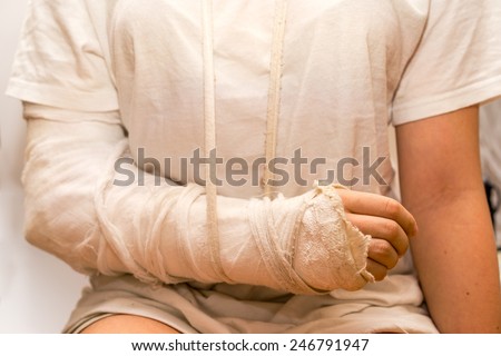 sitting close up girl in front of the camera, wearing the white t-shirt, with the white medicine bandage on injury arm and elbow. the shot illustrated medicine, car and other accidents, violence.