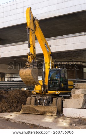 Moscow, Russia April 11, 2015: Modern JCB excavator machinery performs excavation work near the construction, Utility machine used for soil work.