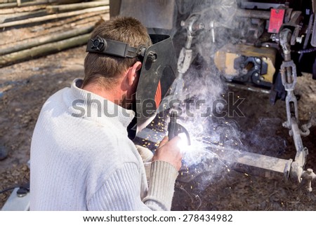welder working with electrode at semi-automatic arc welding