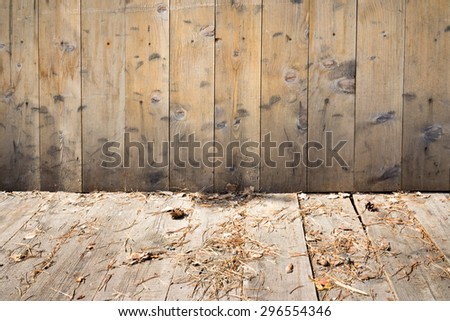 Wooden wall and floor interior with pine needles on the floor
