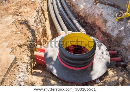 Excavation pit, electrical cables and optical fibres in the digging on a construction site