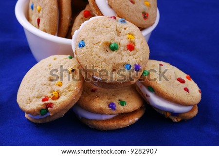 Mini candy chip cream cookies and white bowl on a blue background