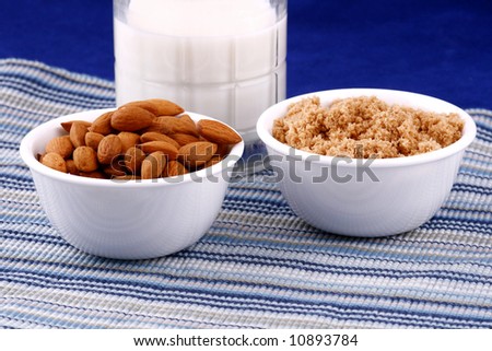 bowl of almonds, bowl of brown sugar and a glass of milk