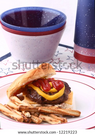 Hamburger with ketchup, mustard, cheese and pretzels with red and white plastic ware