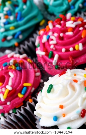 Mini cupcakes on a tilted angle with a shallow depth of field focusing on white cupcake