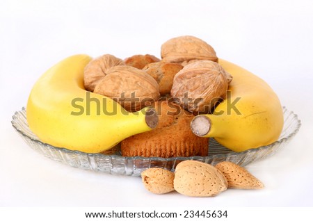 banana nut muffins with nuts and bananas on a clear plate